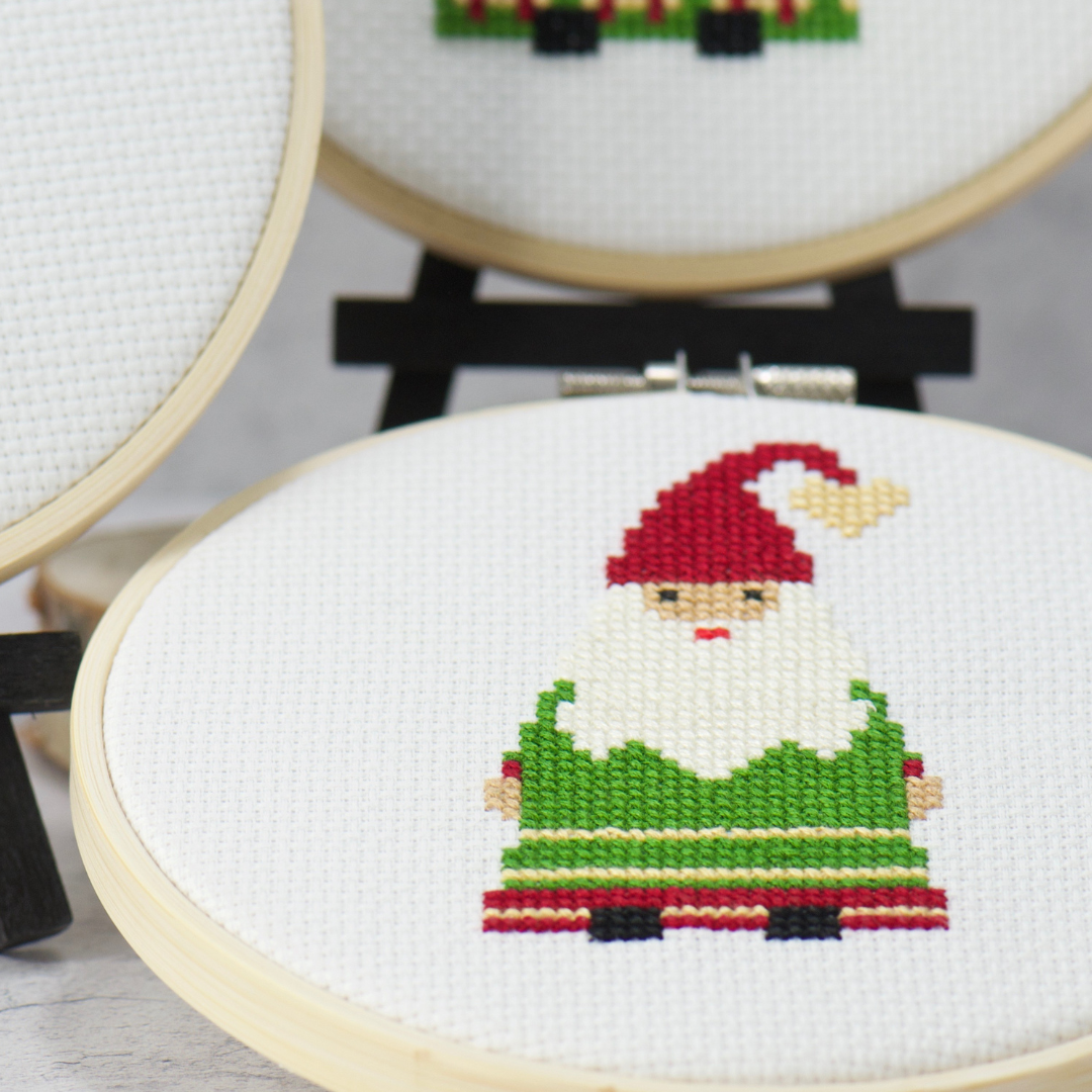 festive christmas gnome in green and red dress with red cap in cross stitch kit