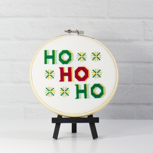 santa claus saying of Ho Ho Ho among snowflake like flowers cross stitch kit