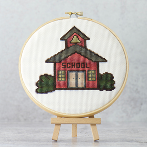 little red schoolhouse with yellow bell in tower surrounded by green bush modern cross stitch instant download digital pattern