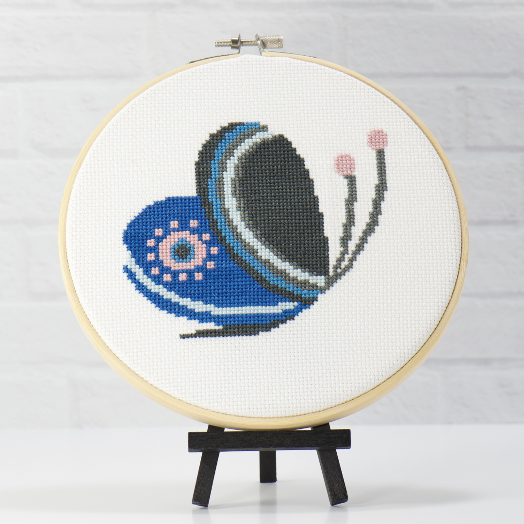 counted cross stitch digital pattern of blue snail with touches of pink perfect for baby's nursery