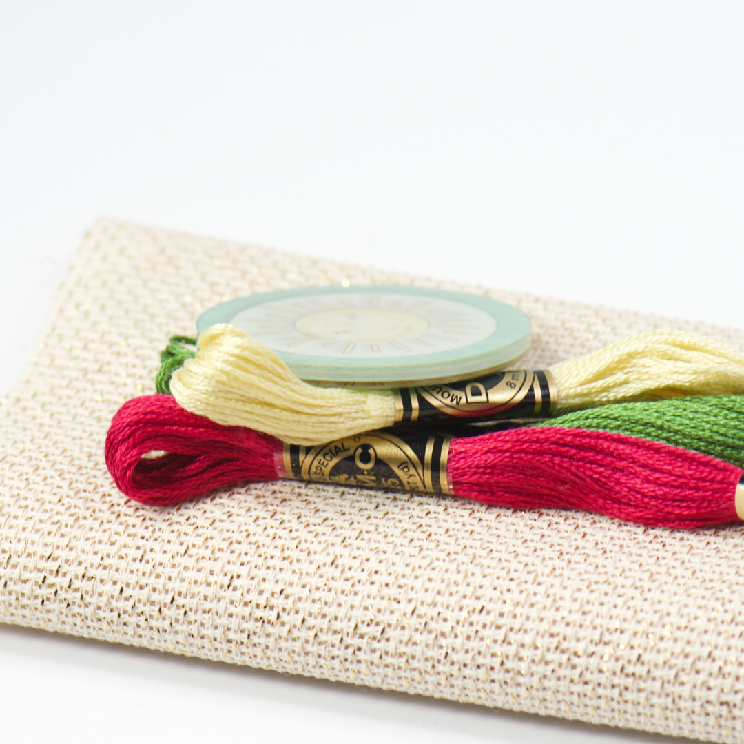 Embroidery floss spools and a reel on a textured fabric surface