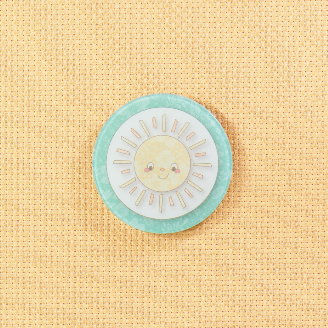 Circular patch with a sun design on a beige fabric background