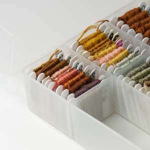 white plastic bobbins fit nicely in craft storage containers for embroidery projects