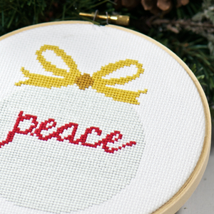 christmas ornament with word peace in counted cross stitch pattern kit