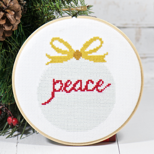 christmas ornament with word peace in counted cross stitch pattern kit